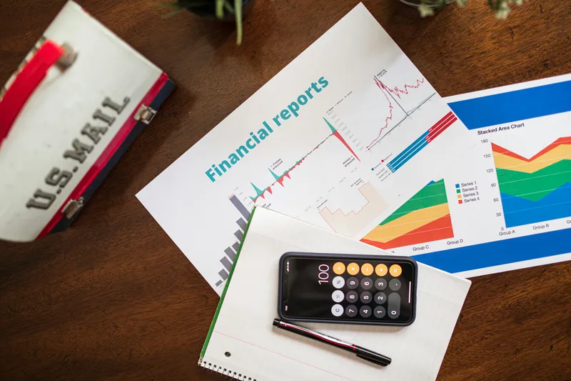 Printed financial reports and charts spread across a table, representing data-driven analysis and strategic planning.