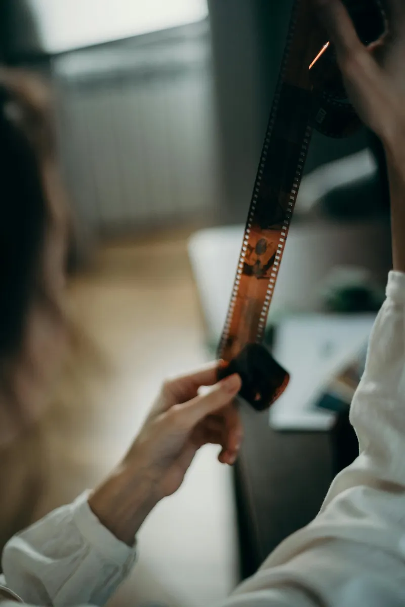 Person observing a photo development process, symbolizing Obscura Studio’s artistic workflow and the transformation from capture to final image.