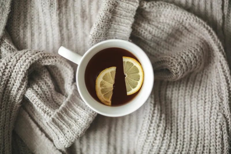 A calming cup of herbal tea with a lemon slice, representing natural wellness and mindful self-care rituals.